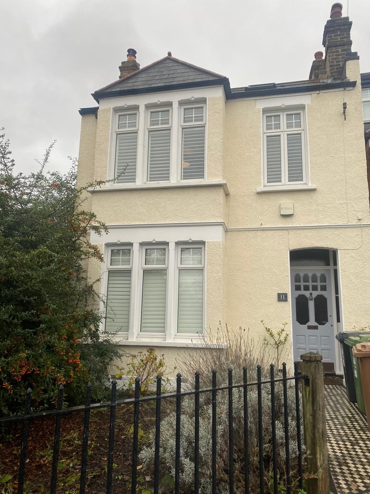 Cream textured render finish on a period bay-fronted house after render repair