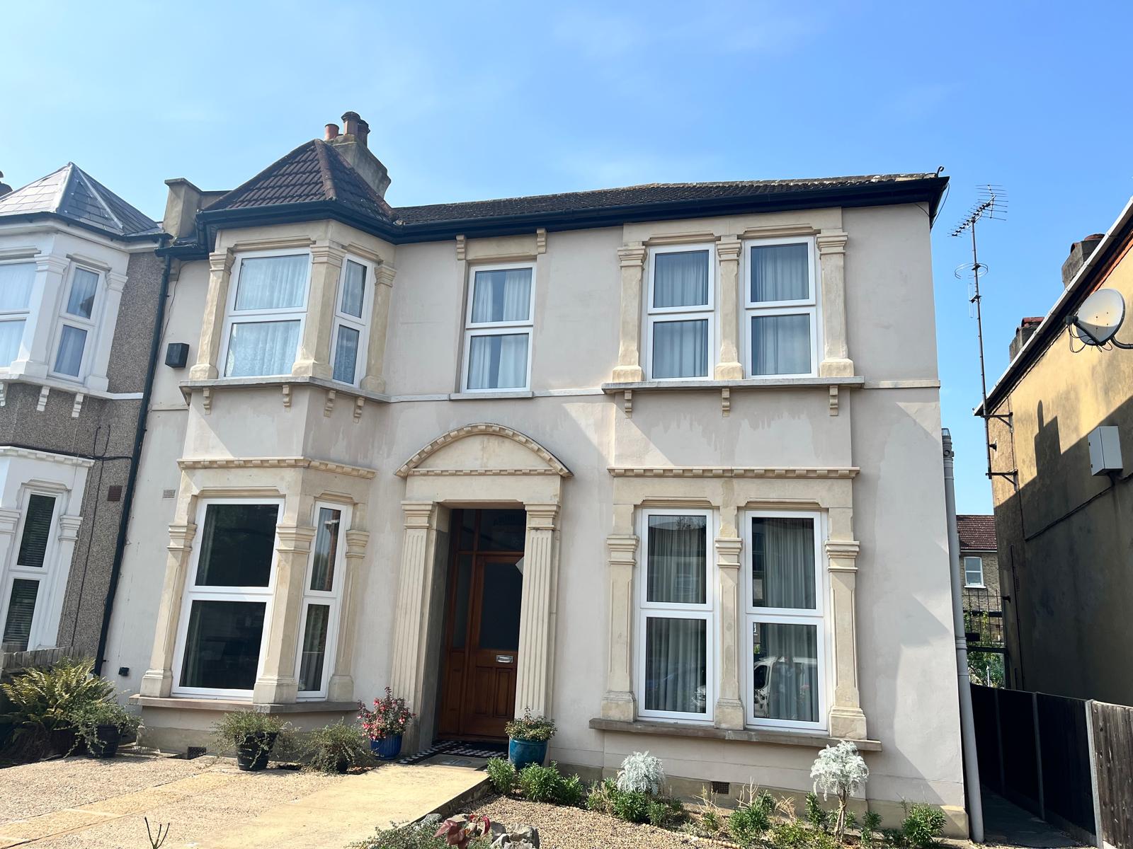 Period semi-detached house with repointed brick chimney stack above the roofline